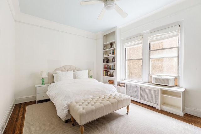 bedroom featuring radiator heating unit, ceiling fan, wood finished floors, cooling unit, and baseboards