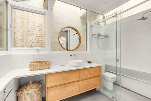 bathroom with tasteful backsplash, vanity, walk in shower, toilet, and tile patterned floors