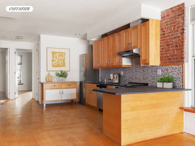 kitchen featuring dishwasher, stove, backsplash, light hardwood / wood-style floors, and kitchen peninsula