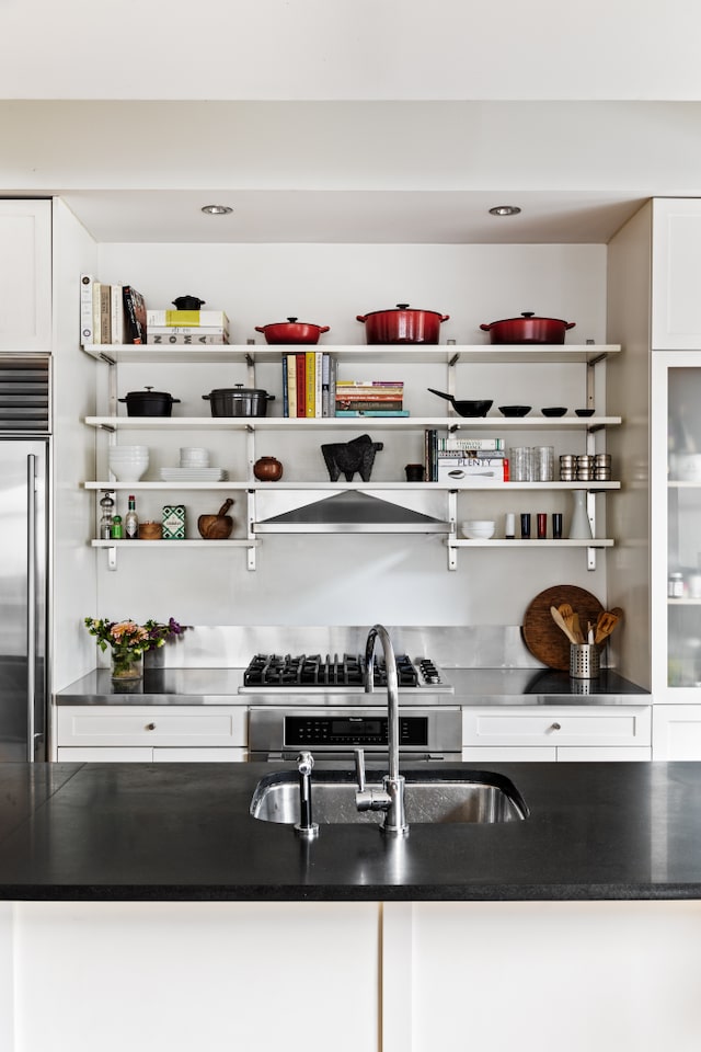 interior space featuring wall chimney range hood, high quality fridge, and a sink