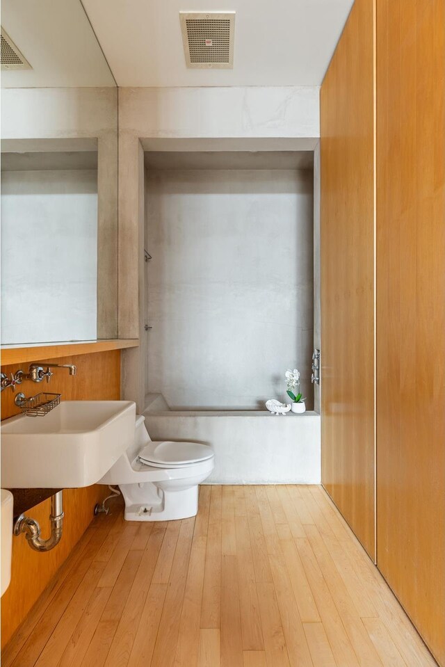 bathroom with toilet and hardwood / wood-style flooring