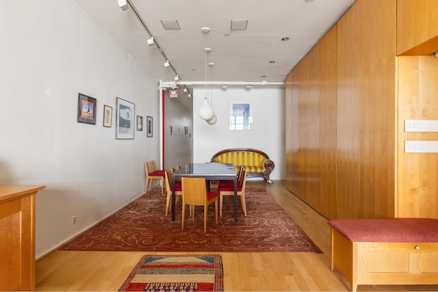 dining space with track lighting and light wood finished floors