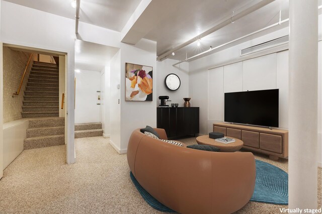 carpeted living room with stairs and baseboards