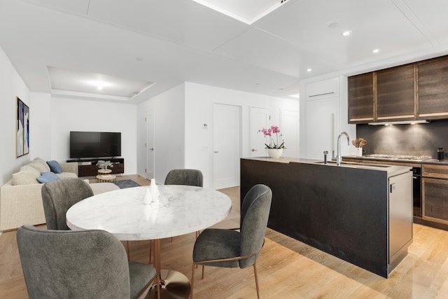 dining area with sink and light hardwood / wood-style floors