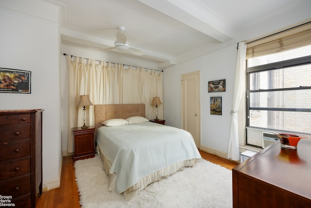 bedroom featuring light wood-type flooring, beam ceiling, baseboards, and cooling unit