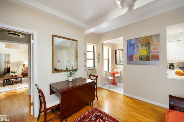 dining area featuring beam ceiling and light wood-type flooring