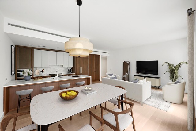 212 W 93rd St Unit 3B, New York City, NY 10025 - kitchen featuring a peninsula, light wood-style floors, light countertops, and a breakfast bar