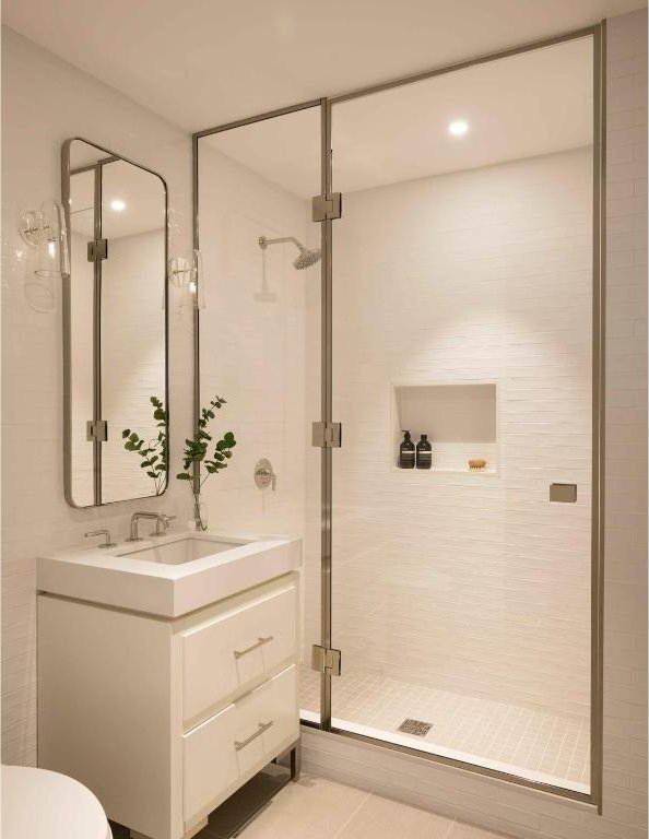 bathroom featuring walk in shower, vanity, and tile patterned flooring