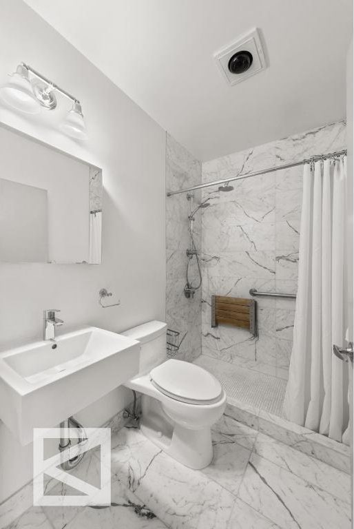 bathroom with toilet and a shower with curtain