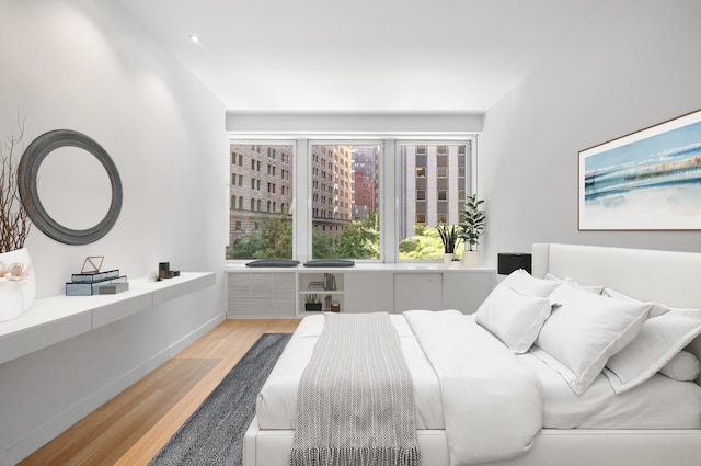 bedroom with wood finished floors and baseboards