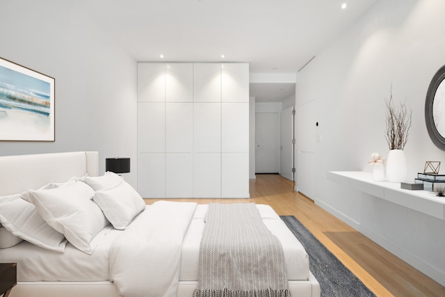 bedroom with light hardwood / wood-style flooring and a closet