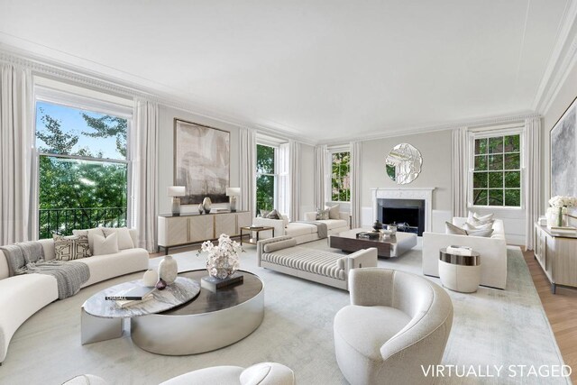 living room with crown molding, a healthy amount of sunlight, and light wood-type flooring