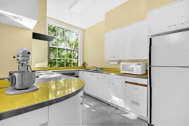 kitchen with white cabinetry, sink, and white appliances