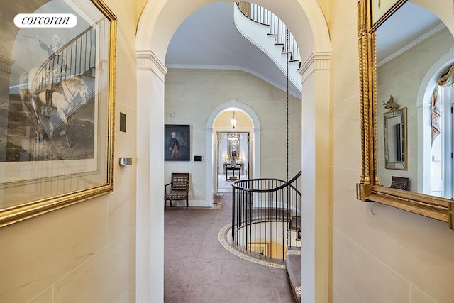 corridor with crown molding and a chandelier