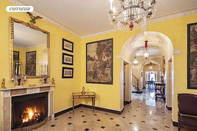 corridor with baseboards, arched walkways, stairs, crown molding, and a chandelier