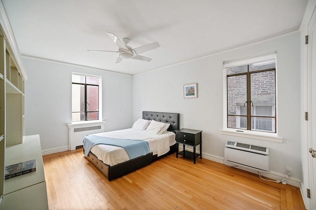 bedroom featuring ceiling fan, baseboards, light wood-style flooring, and radiator