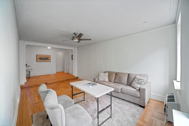 living room featuring ceiling fan, light parquet flooring, and ornamental molding