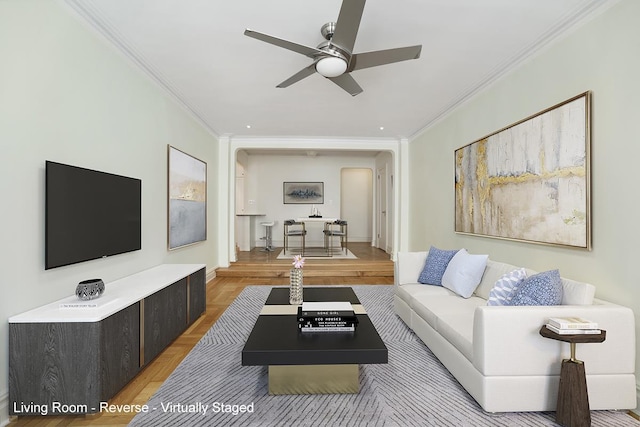 living room featuring ceiling fan and crown molding