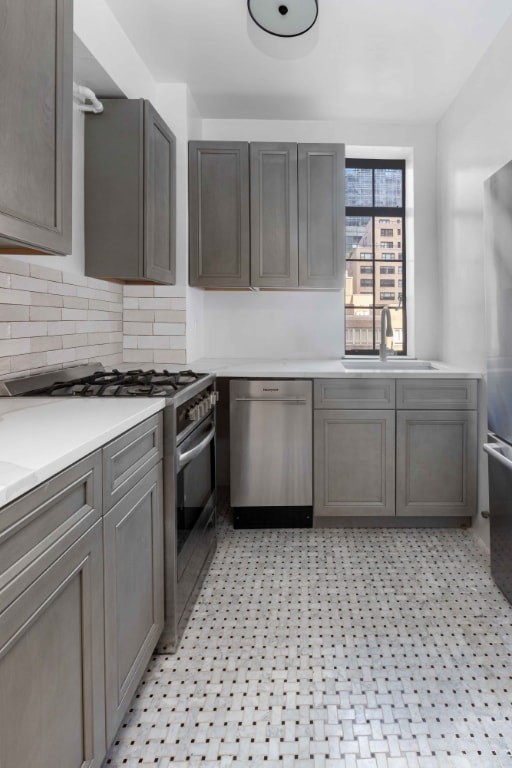 kitchen with sink, stainless steel appliances, and tasteful backsplash