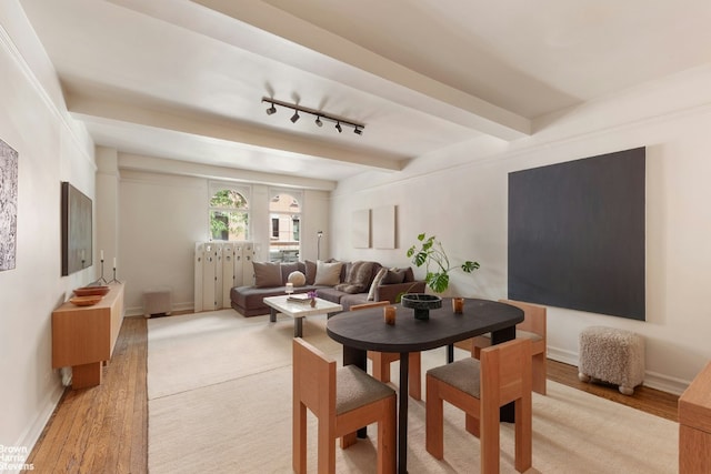 dining space featuring beamed ceiling, track lighting, and light wood-type flooring