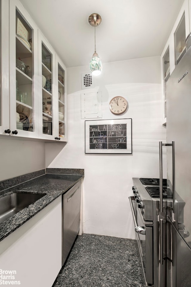 kitchen featuring appliances with stainless steel finishes, glass insert cabinets, visible vents, and white cabinetry