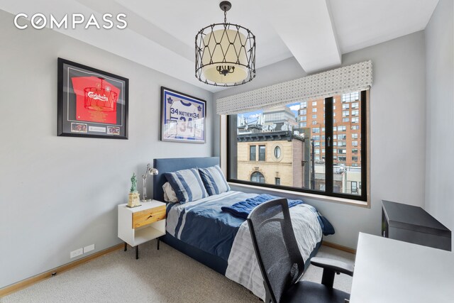 carpeted bedroom with baseboards and an inviting chandelier