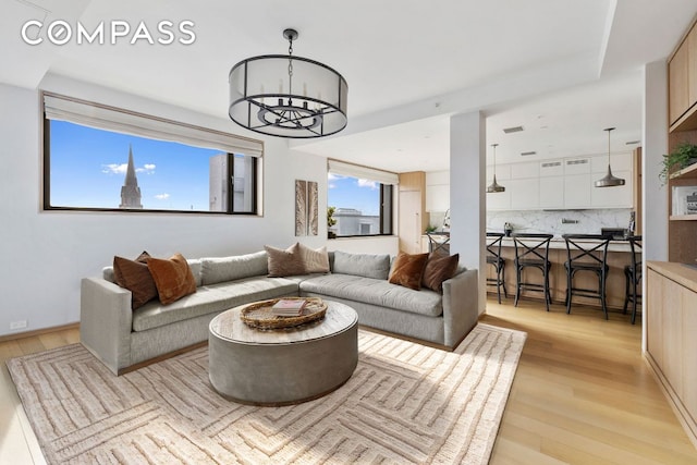 living room with a notable chandelier and light wood-type flooring