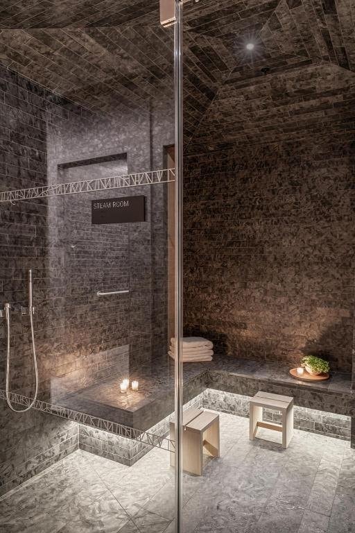 bathroom with lofted ceiling, brick ceiling, and a shower