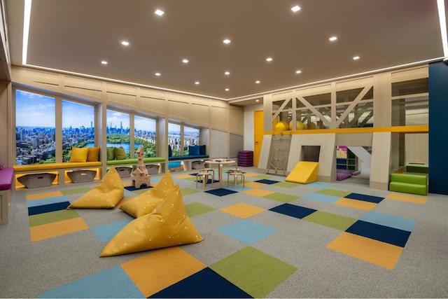 recreation room with carpet, expansive windows, and a healthy amount of sunlight