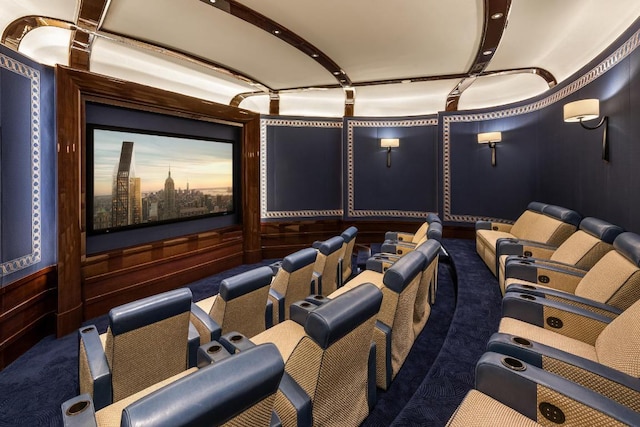 carpeted cinema room featuring wood walls