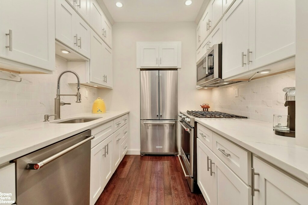 208 W 119th St Unit 2G, New York City, NY 10026 - kitchen featuring appliances with stainless steel finishes, a sink, decorative backsplash, white cabinets, and recessed lighting