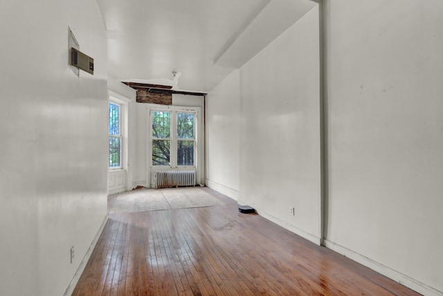 empty room featuring radiator and light hardwood / wood-style flooring