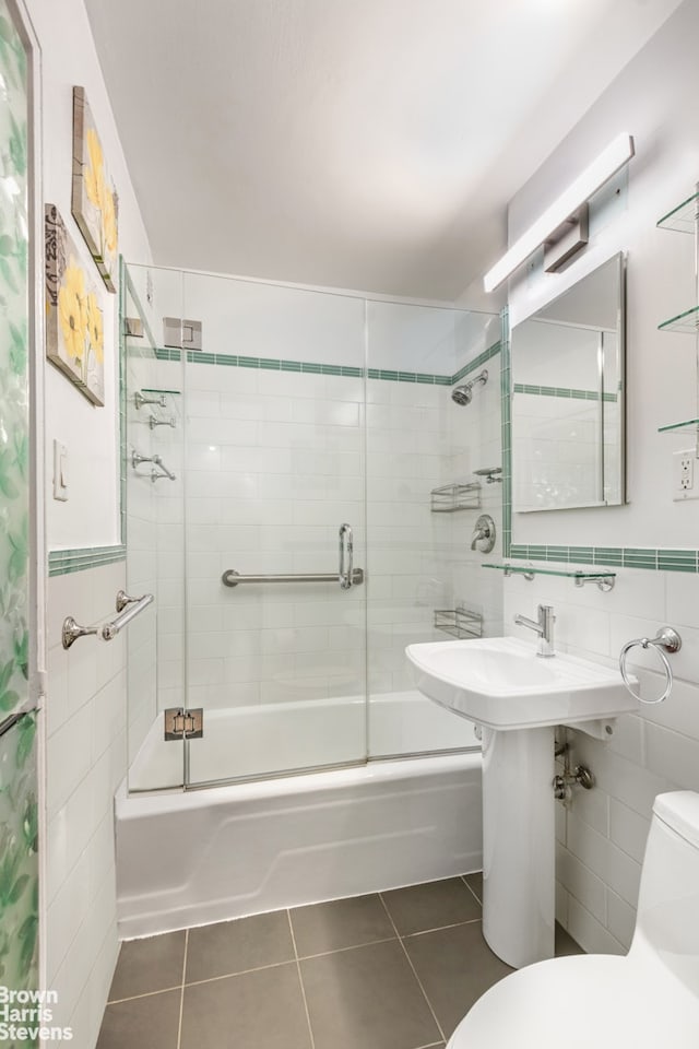 full bath featuring tile patterned floors, toilet, tile walls, and enclosed tub / shower combo