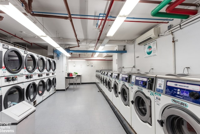 community laundry room featuring a wall mounted air conditioner and separate washer and dryer