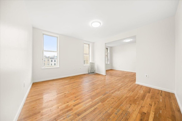 spare room featuring light wood-type flooring and radiator heating unit