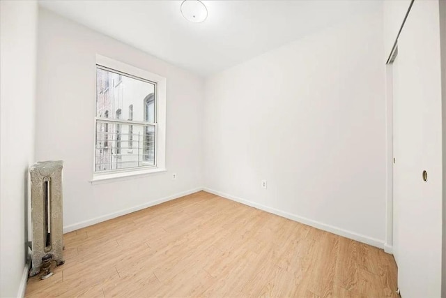 spare room with light wood-type flooring and radiator heating unit