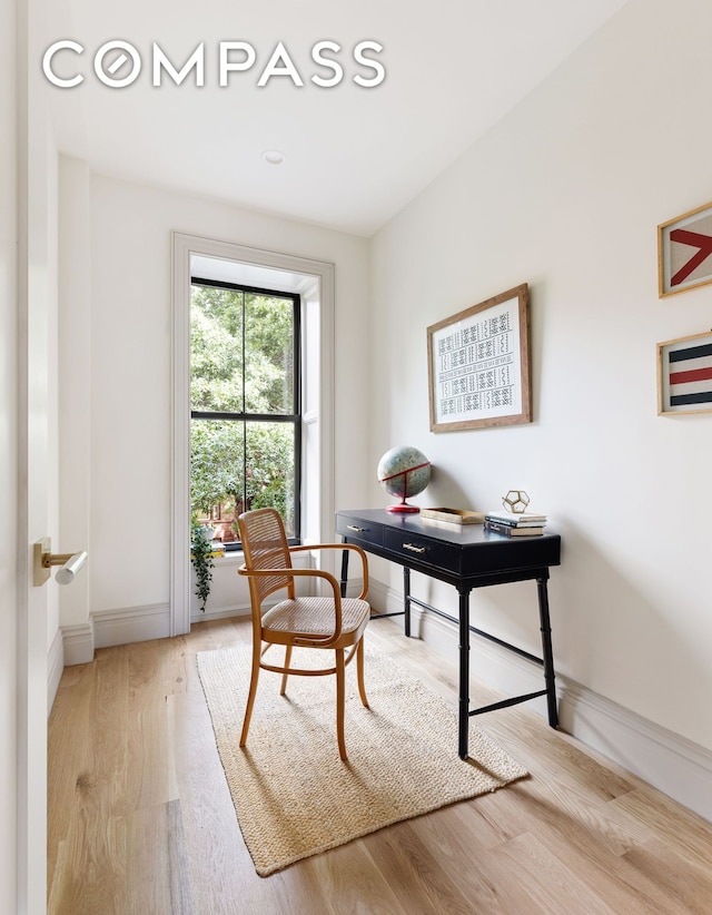 office area with baseboards and light wood finished floors