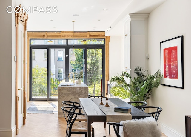 doorway featuring a wall of windows, plenty of natural light, and baseboards