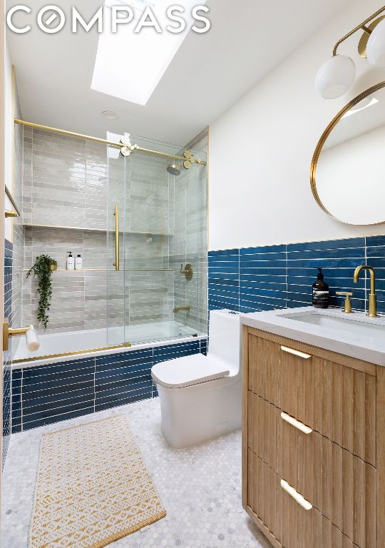 full bathroom featuring tile walls, tiled shower / bath combo, vanity, toilet, and tile patterned floors