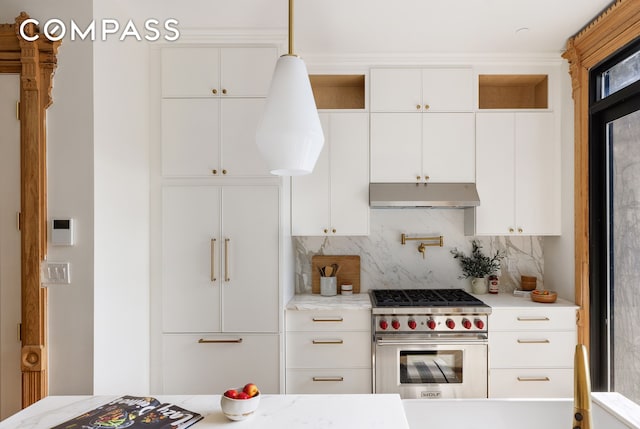 kitchen featuring under cabinet range hood, backsplash, luxury range, and white cabinetry