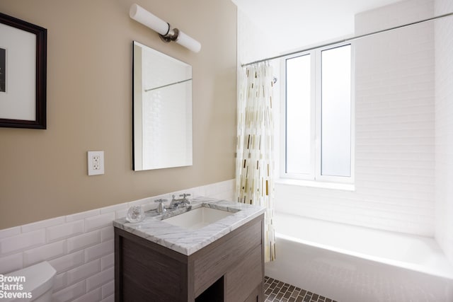 full bathroom with tile walls, vanity, shower / bath combination with curtain, tile patterned floors, and toilet