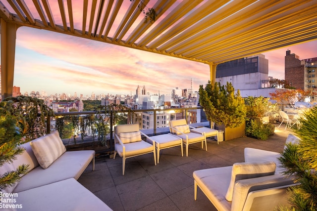 patio terrace at dusk with a balcony and an outdoor hangout area