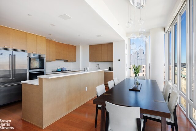 kitchen featuring stainless steel appliances, dark wood-type flooring, sink, and beverage cooler