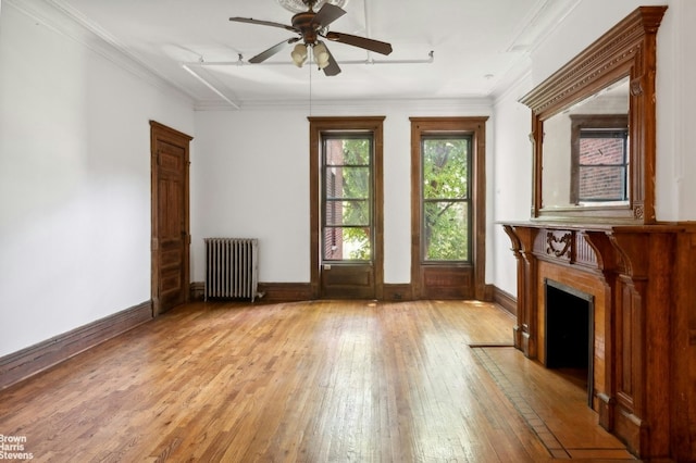 unfurnished living room with radiator, ceiling fan, ornamental molding, and light hardwood / wood-style flooring