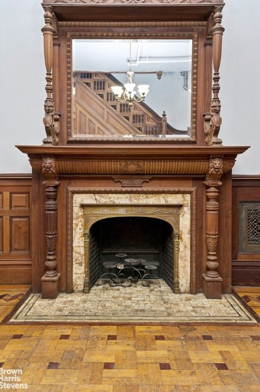 unfurnished living room featuring light wood-type flooring, a notable chandelier, and crown molding