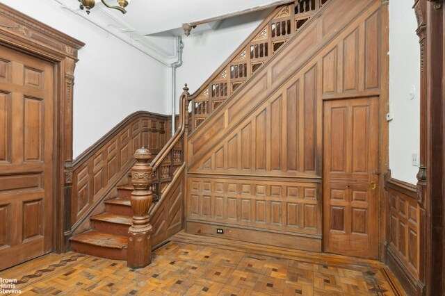 unfurnished living room with cooling unit, radiator heating unit, crown molding, and light hardwood / wood-style flooring