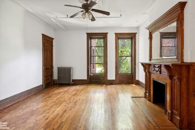 unfurnished living room featuring ceiling fan, cooling unit, dark hardwood / wood-style floors, and radiator heating unit