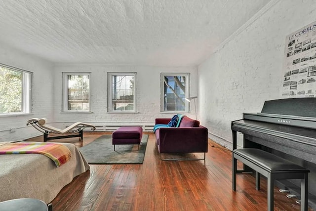bedroom with wood-type flooring, a textured ceiling, and a textured wall