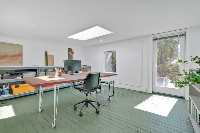 office with a skylight, wood finished floors, and healthy amount of natural light
