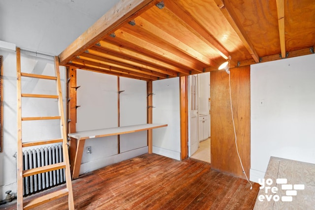 basement with hardwood / wood-style flooring and radiator heating unit